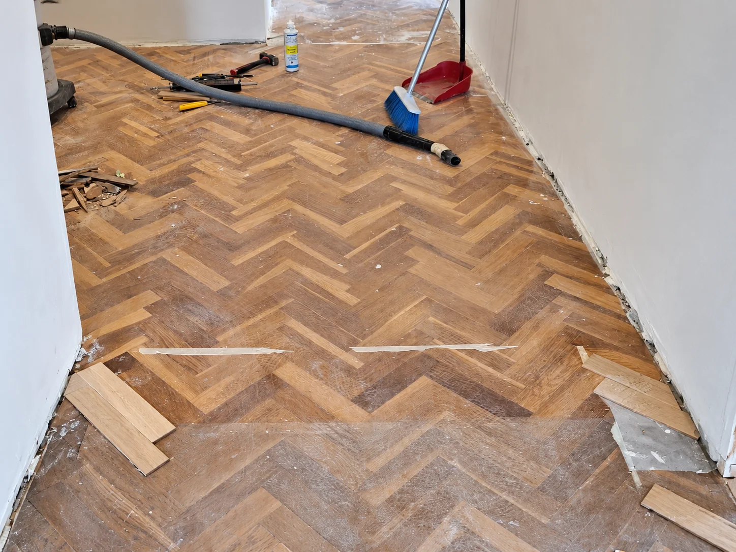 Reparació de lames en un parquet en espiga durant l’obra